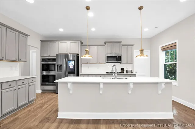 a large kitchen with kitchen island a stove a sink a center island and cabinets