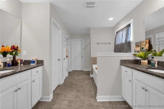 a kitchen with white cabinets and sink