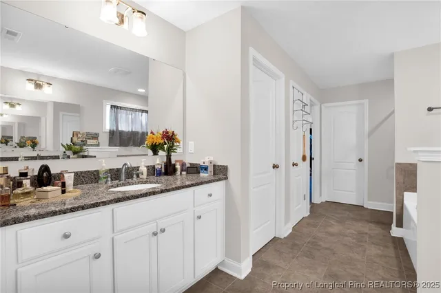 a spacious bathroom with double sink and a mirror