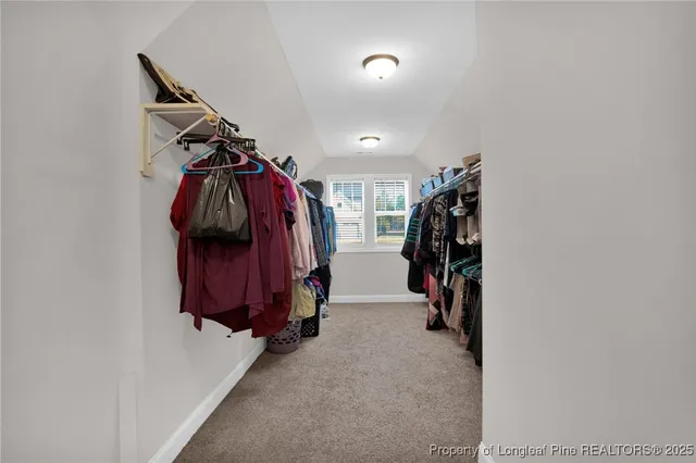a view of walk in closet with clothes