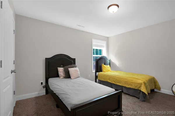a bedroom with two beds and a potted plant