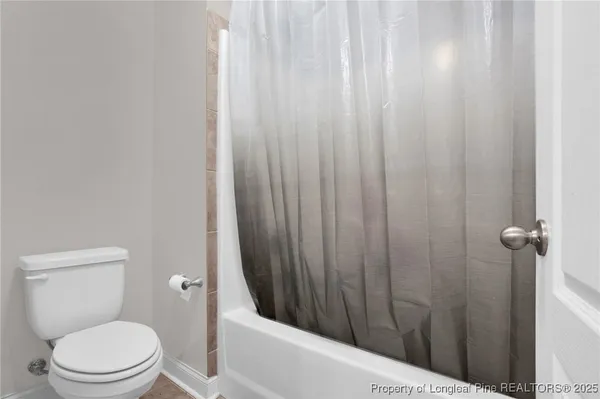 a bathroom with a toilet and a shower curtain
