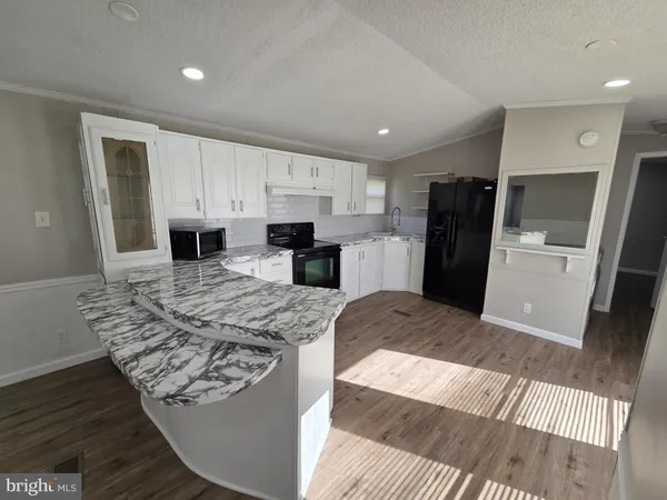 a kitchen with a refrigerator and white cabinets