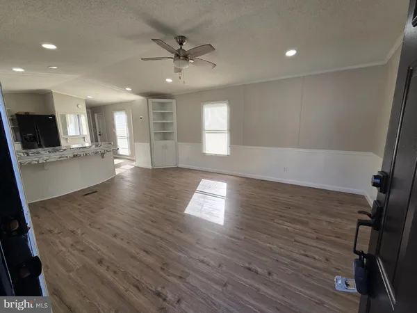 a view of empty room with kitchen and fireplace