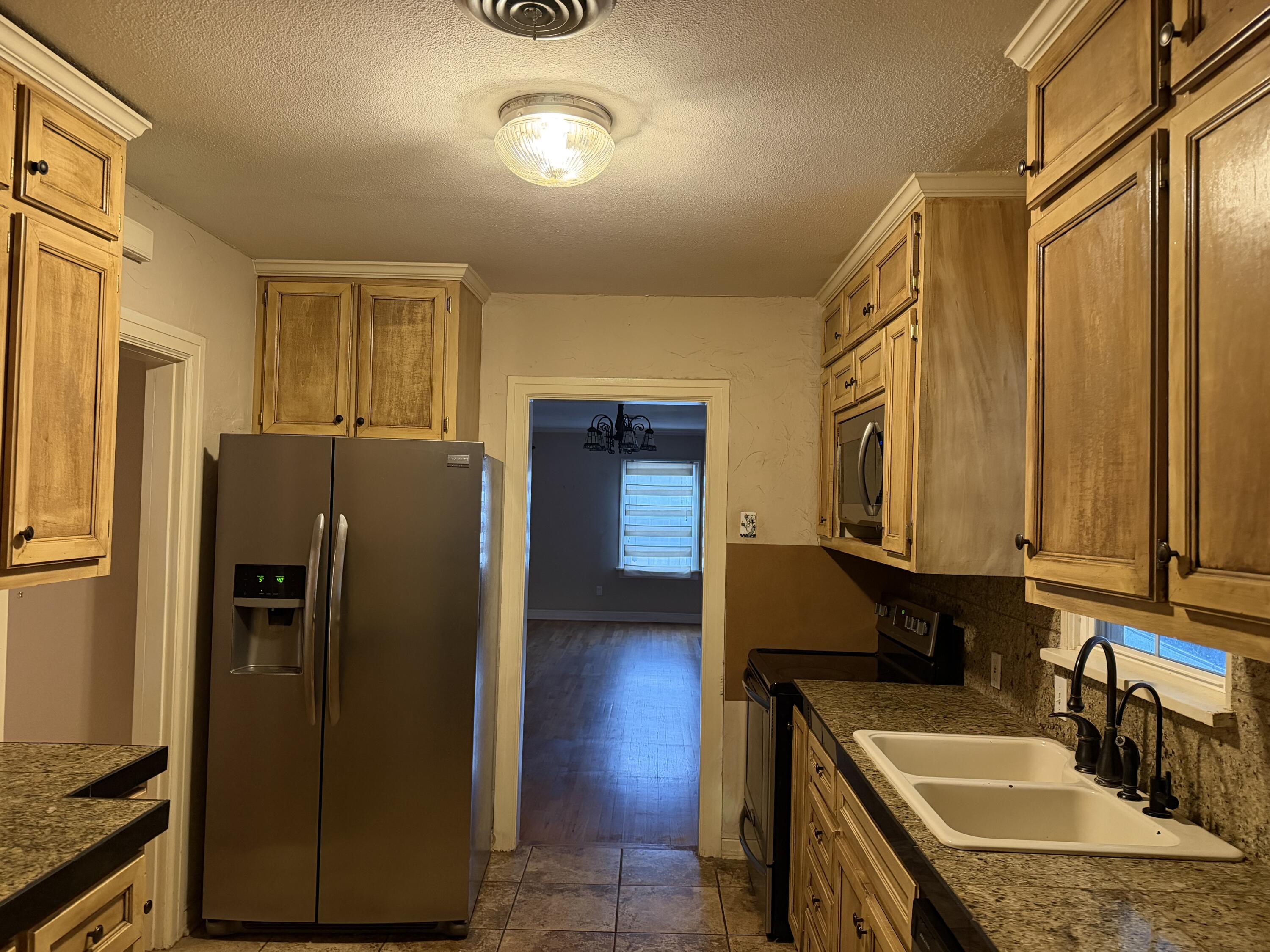 3110 22nd Street Lubbock, TX 79410 - Photo 4 of 22 a kitchen with stainless steel appliances granite countertop a refrigerator a sink and dishwasher
