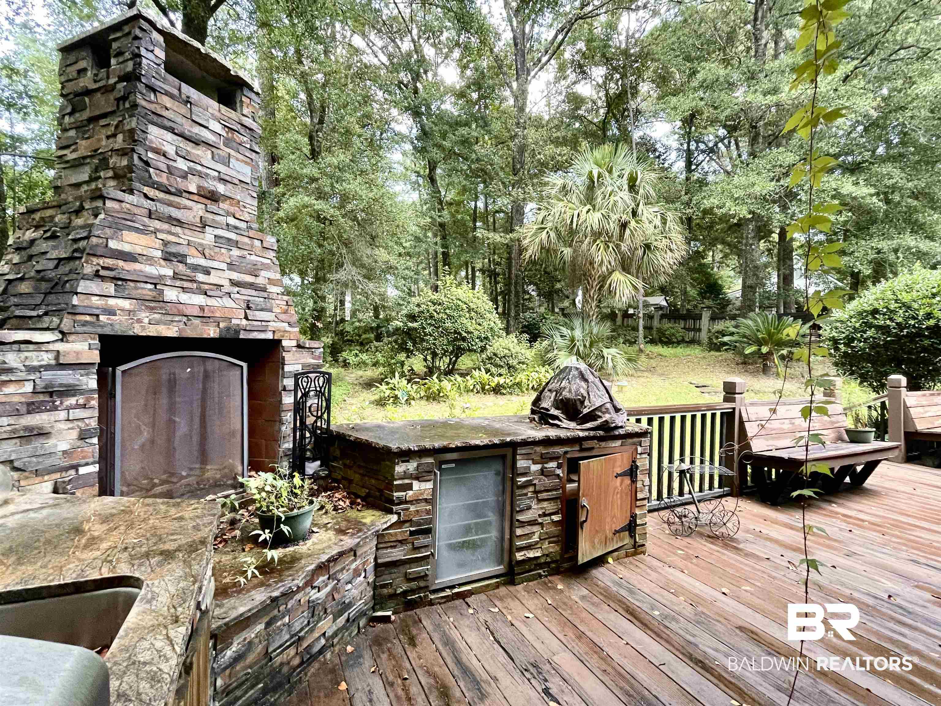 202 Potters Mills Road Daphne, AL 36526 - Photo 26 of 29 Wooden deck featuring exterior kitchen and an outdoor stone fireplace