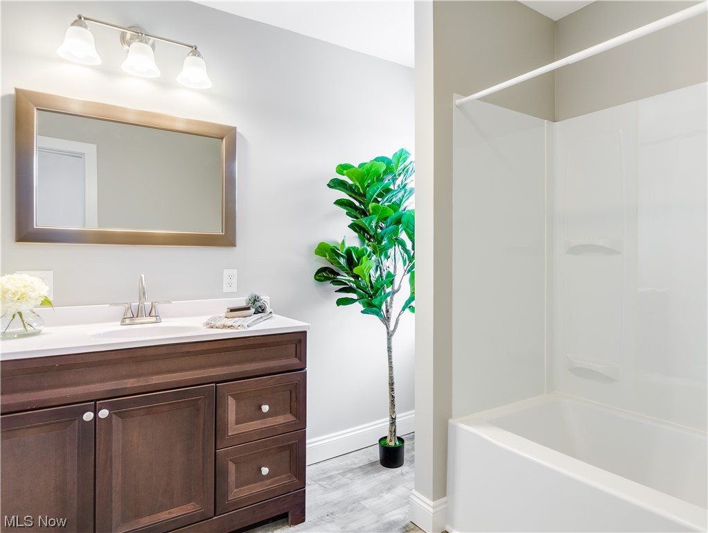 672 Brittain Road Akron, OH 44305 - Photo 22 of 24 Bathroom featuring wood-type flooring, shower combination, and vanity