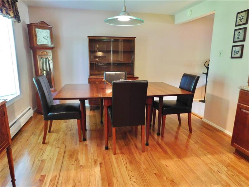 935 Ruth Street Pittsburgh, PA 15243 - Photo 5 of 25 Ample dining room is extension of open kitchen. Beautiful hardwood floors underfoot. Another bay window frames a backyard and sunset view.