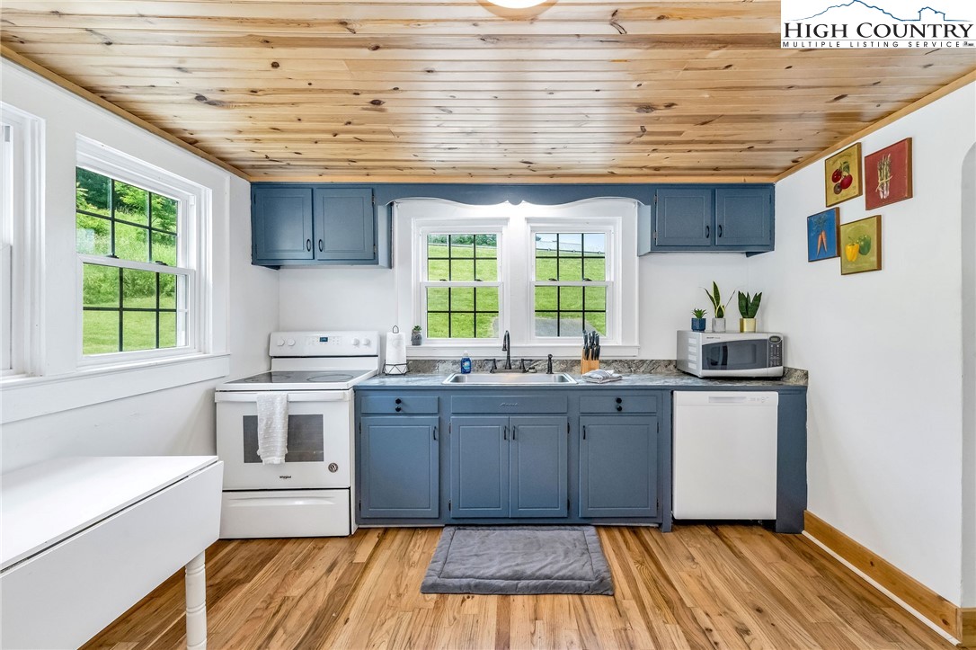 609 West Main Street Jefferson, NC 28640 - Photo 12 of 42 a kitchen with kitchen island granite countertop a sink and a stove next to a window