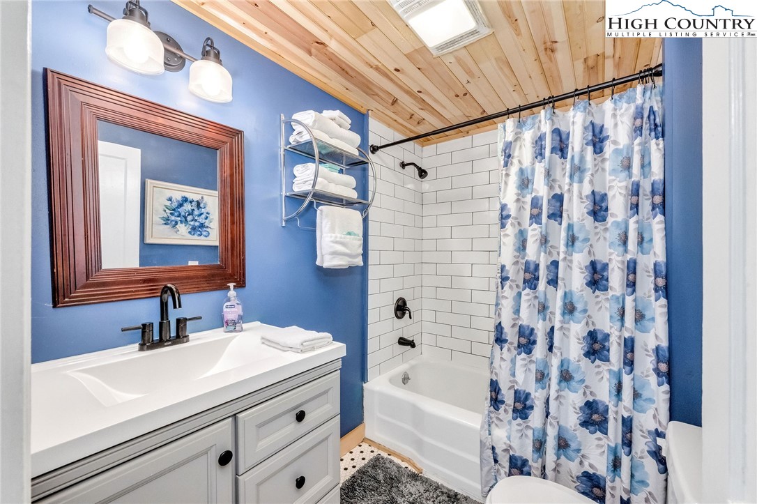 609 West Main Street Jefferson, NC 28640 - Photo 24 of 42 a bathroom with a sink a mirror a bathtub and shower