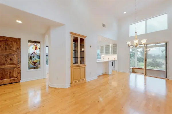 a view of a big room with wooden floor and windows