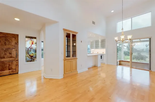 a view of a big room with wooden floor and windows