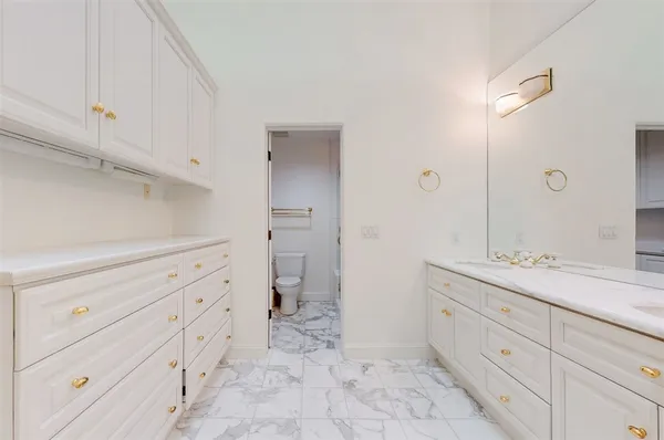 a bathroom with a granite countertop toilet and a shower