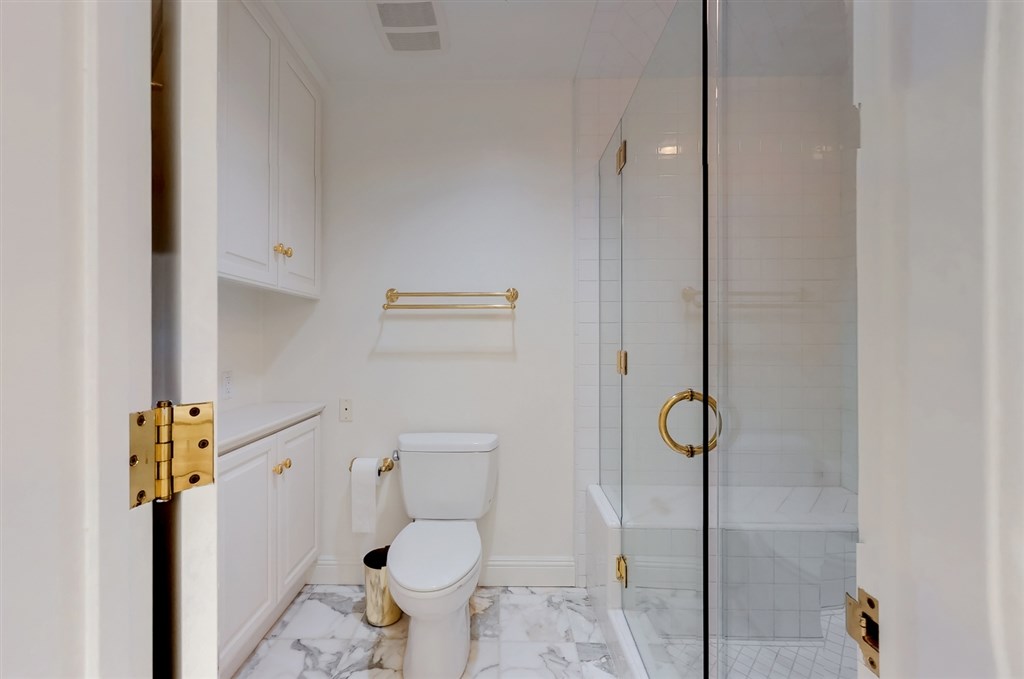 12211 Bajada Road San Diego, CA 92128 - Photo 14 of 23 a bathroom with a granite countertop toilet and a shower