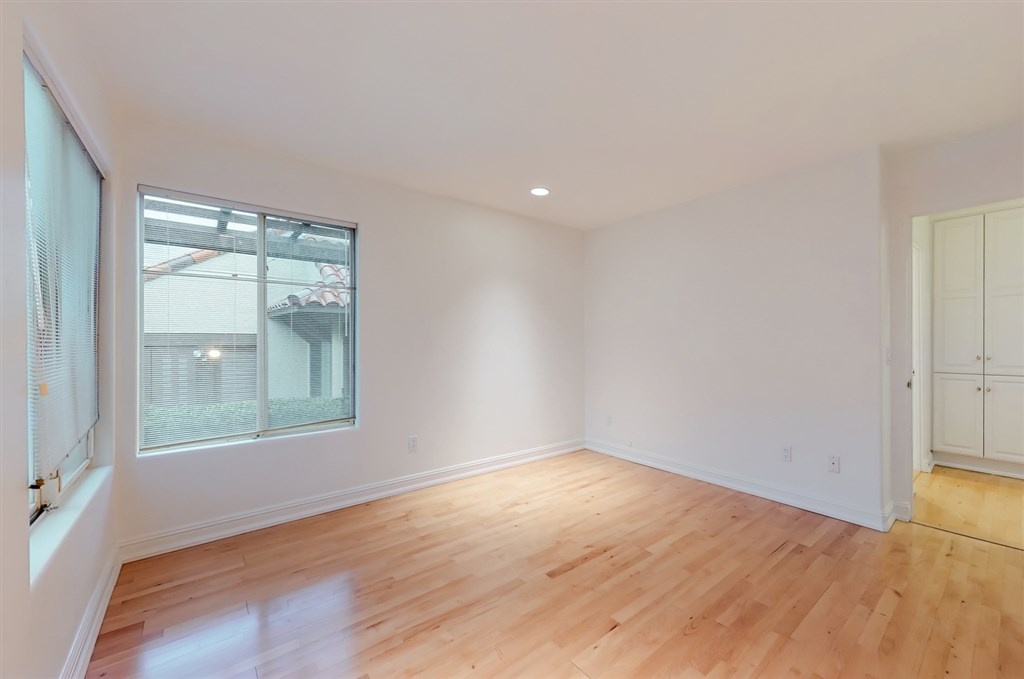 12211 Bajada Road San Diego, CA 92128 - Photo 16 of 23 an empty room with wooden floor and windows