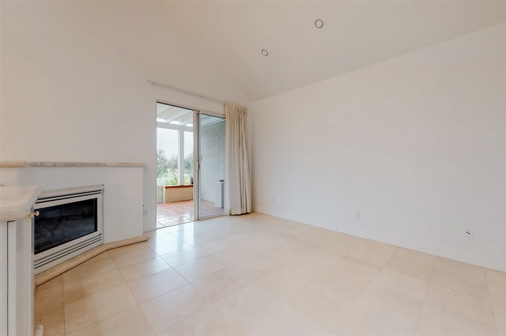 12211 Bajada Road San Diego, CA 92128 - Photo 6 of 23 a view of an empty room with a fireplace and a window