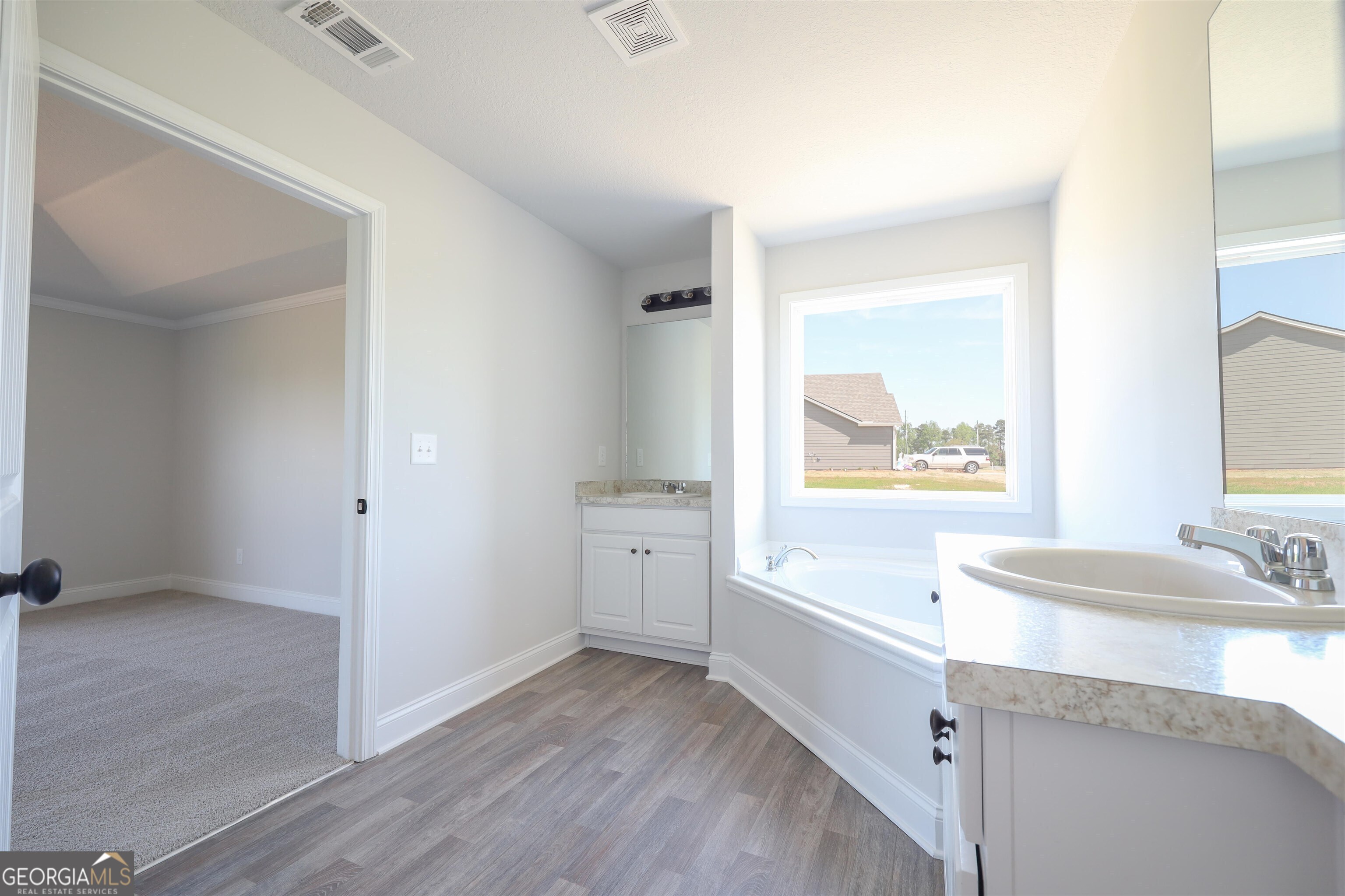 463 Tanners Bridge Road, Unit 2 Bethlehem, GA 30620 - Photo 6 of 6 a bathroom with a granite countertop sink mirror and bathtub