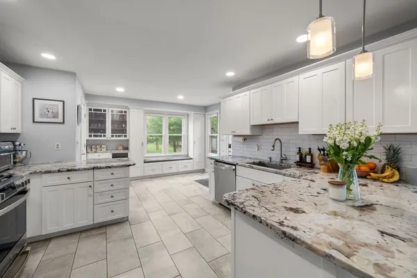 a kitchen with stainless steel appliances granite countertop a stove a sink and a microwave