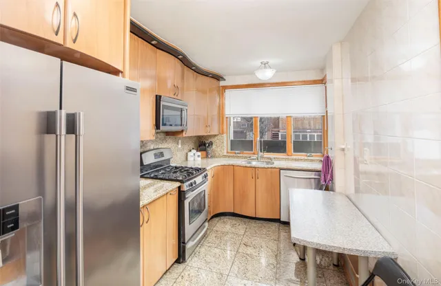 a kitchen with stainless steel appliances granite countertop a stove a refrigerator and a stove top oven