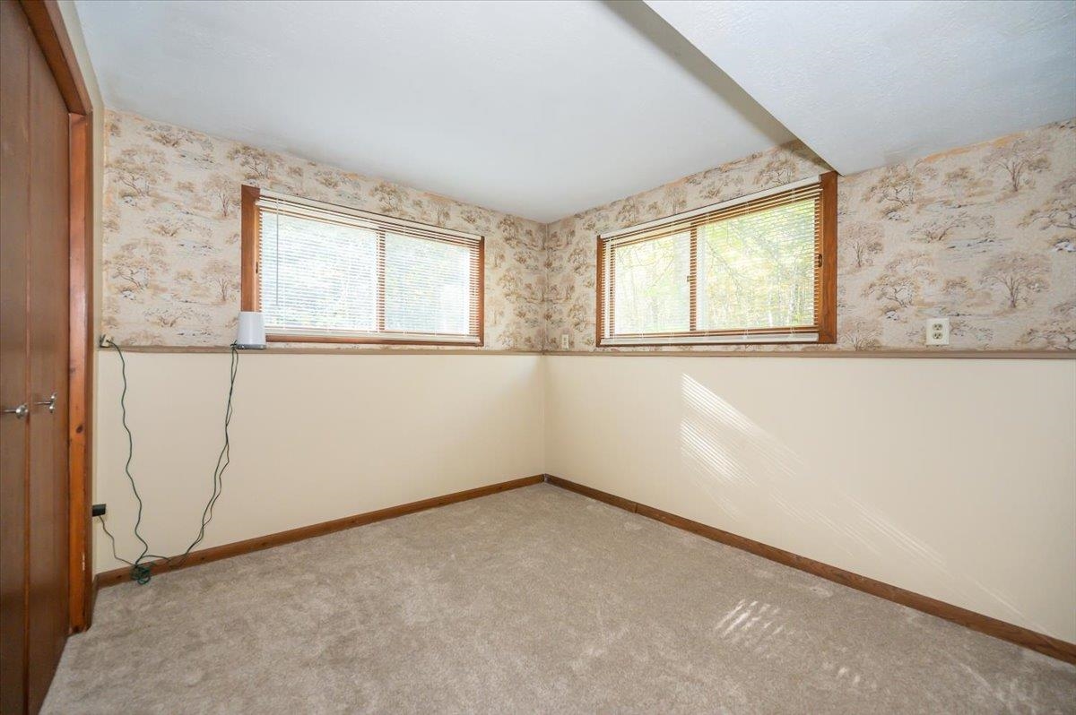 6891 South Oakland Road Superior, WI 54880 - Photo 18 of 29 Carpeted empty room with wallpapered walls and wainscoting