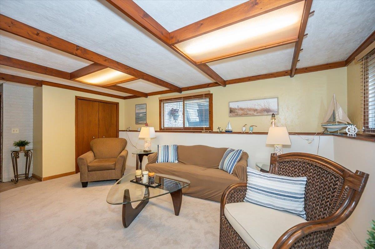 6891 South Oakland Road Superior, WI 54880 - Photo 20 of 29 Living room featuring beam ceiling, carpet flooring, and a textured ceiling
