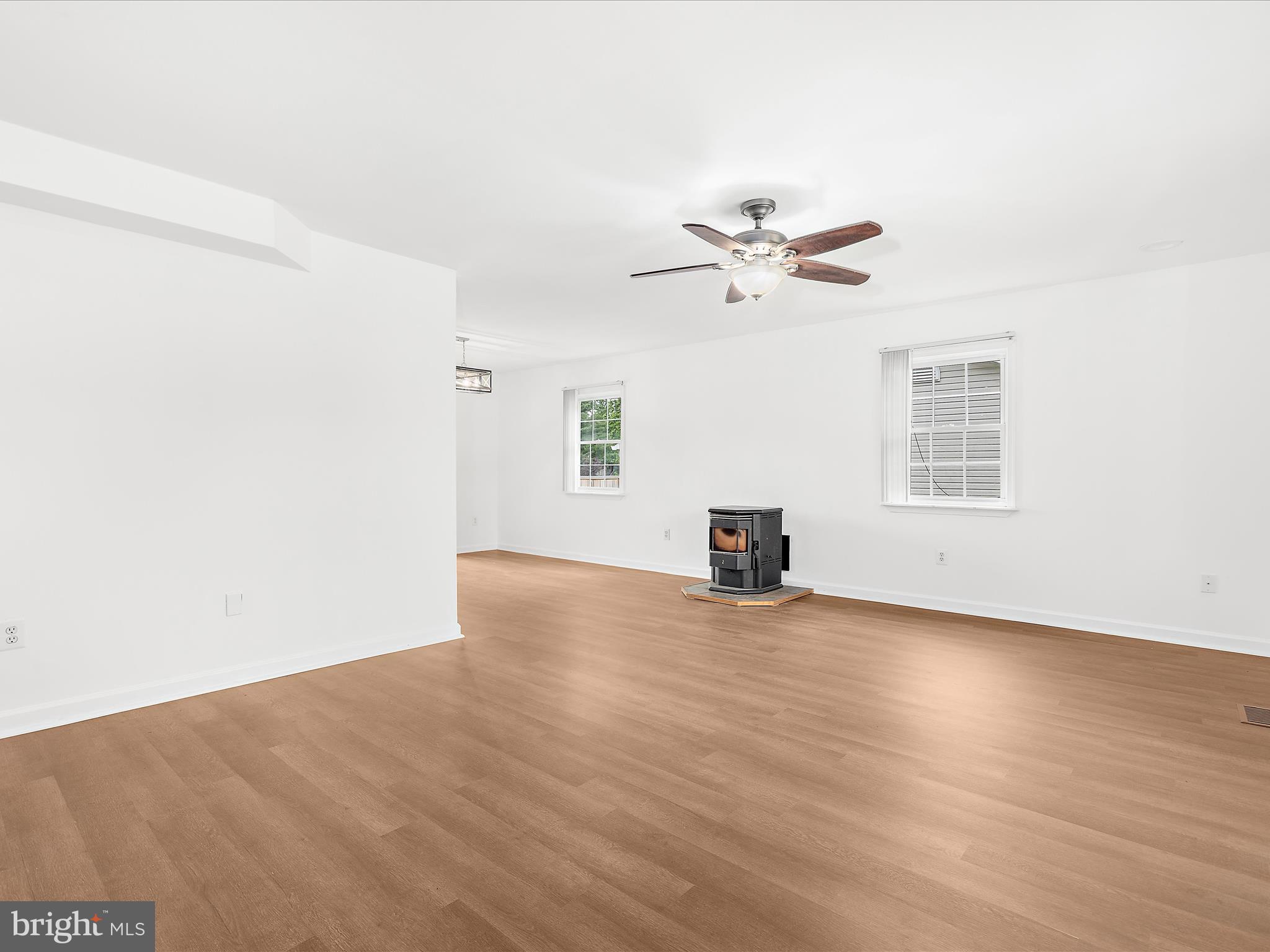 8475 Sexton Road Pasadena, MD 21122 - Photo 17 of 58 an empty room with wooden floor chandelier fan and windows