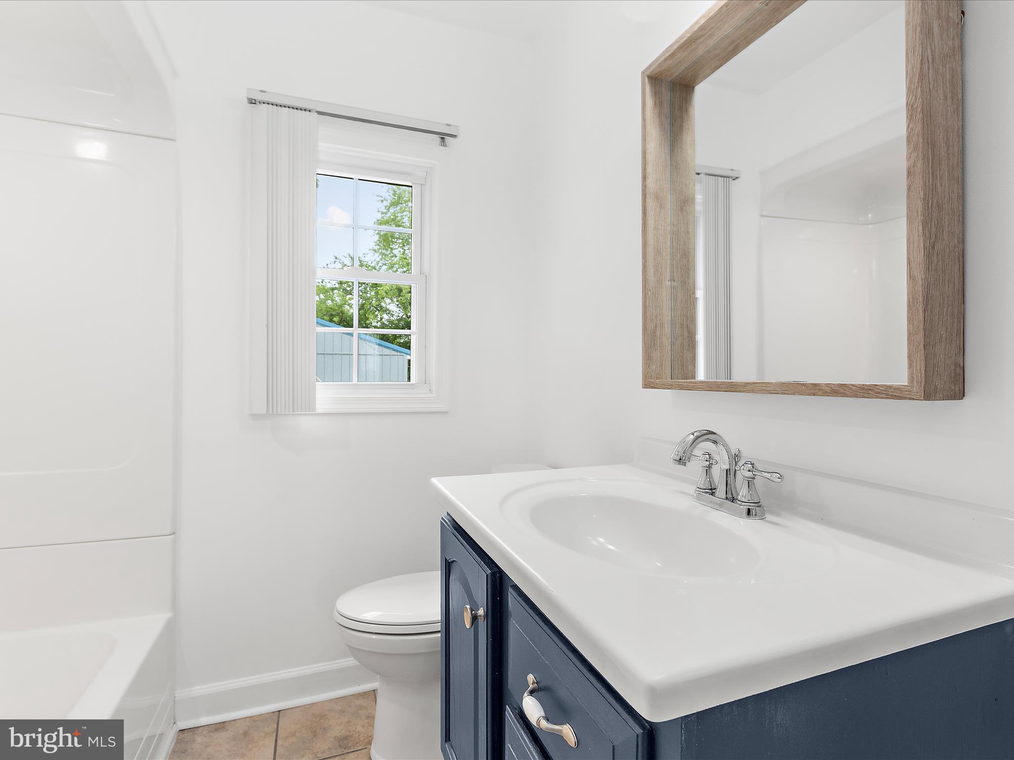 8475 Sexton Road Pasadena, MD 21122 - Photo 31 of 58 a bathroom with a sink a toilet and a mirror