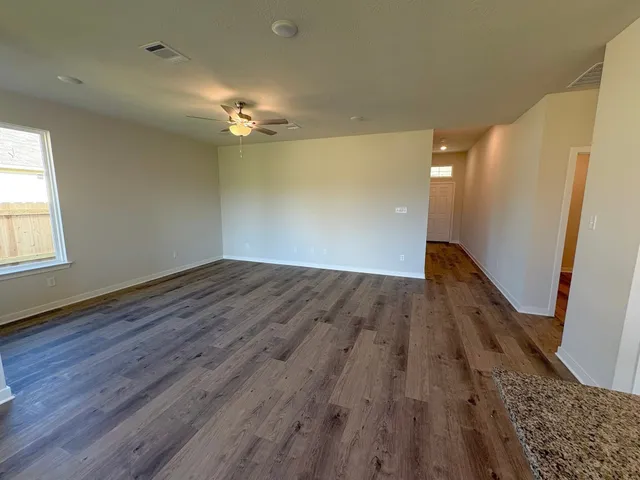 wooden floor in an empty room with a window