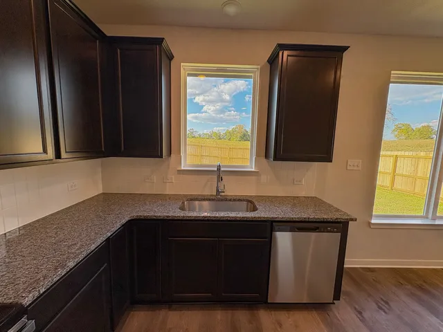 a kitchen with granite countertop a sink and a window