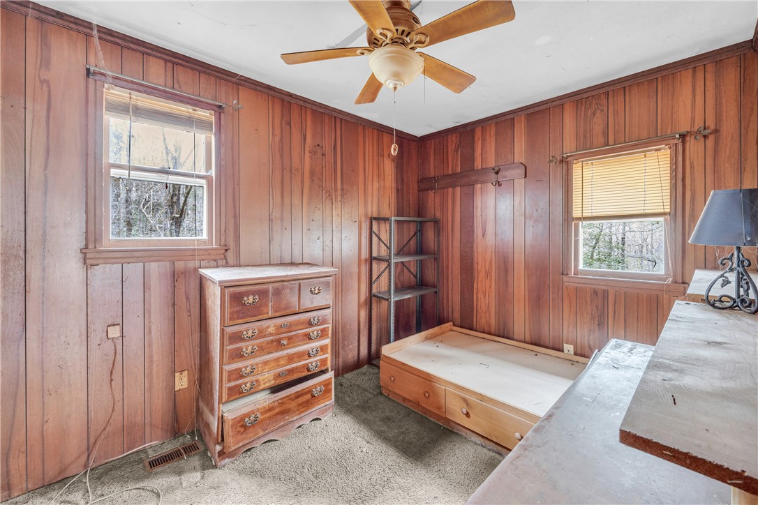 115 Little Stakey Rd Mountain Rest Mountain Rest, SC 29664 - Photo 16 of 38 This cozy bedroom features warm wood paneling and provides serene views of nature.