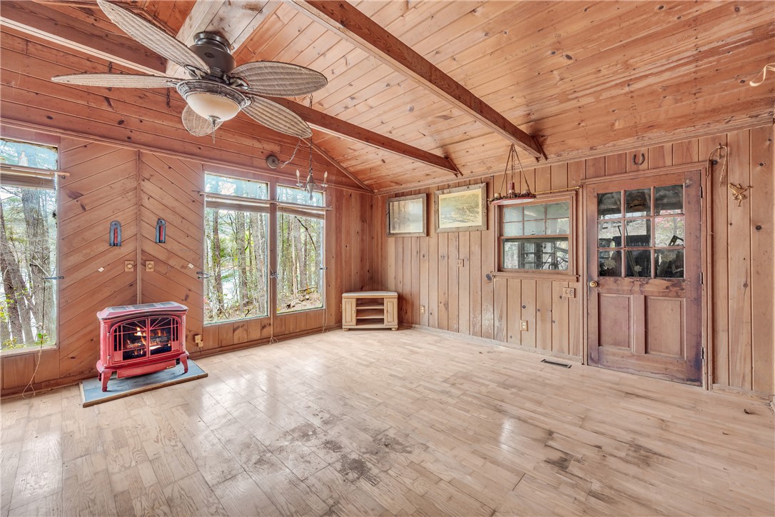 115 Little Stakey Rd Mountain Rest Mountain Rest, SC 29664 - Photo 8 of 38 This inviting room features vaulted wood ceilings and expansive windows, offering tranquil nature views.