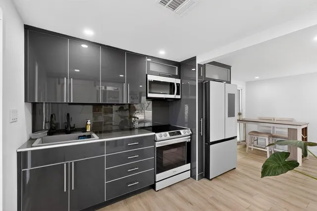 a kitchen with wooden cabinets and stainless steel appliances