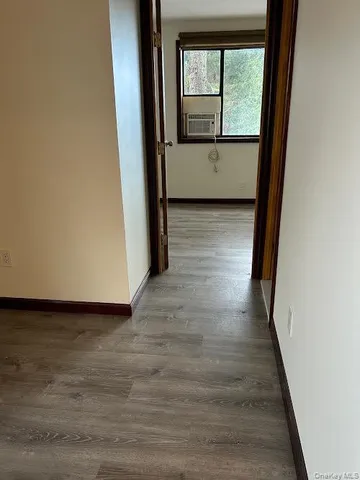 a view of a room with wooden floor and a window