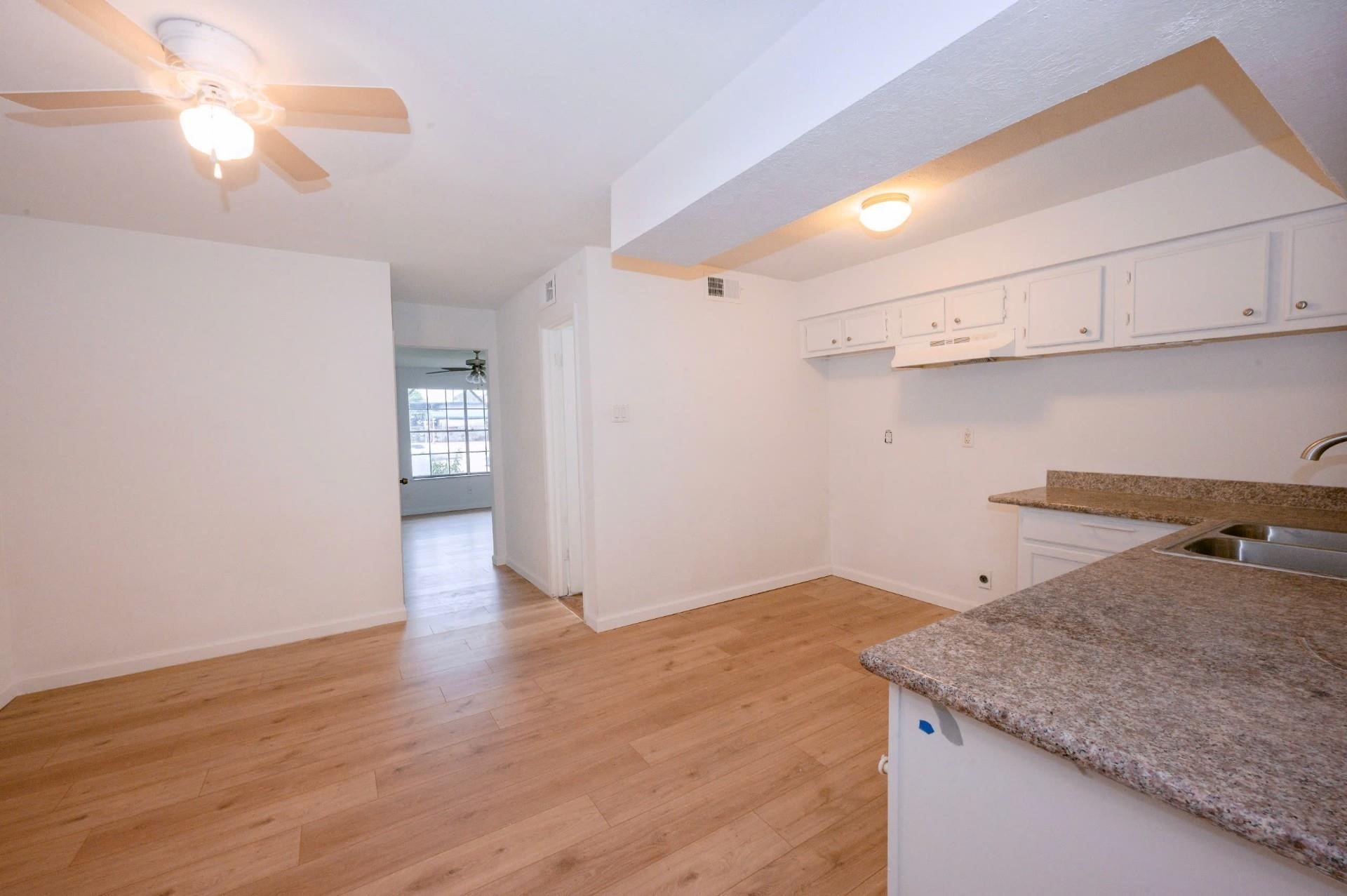 12048 Beechnut Street Houston, TX 77072 - Photo 1 of 13 a kitchen with cabinets and wooden floor