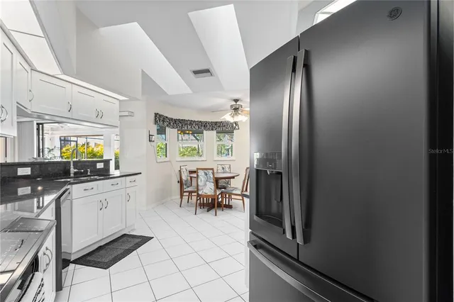 a kitchen with a dining table chairs cabinets and stainless steel appliances