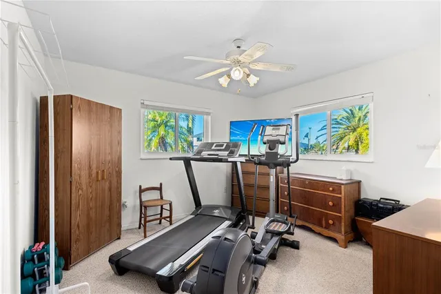 a bedroom with a large bed couch and windows