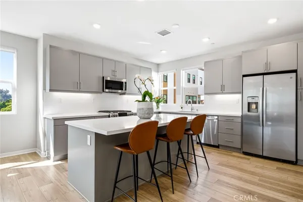 a kitchen with a dining table chairs and white appliances