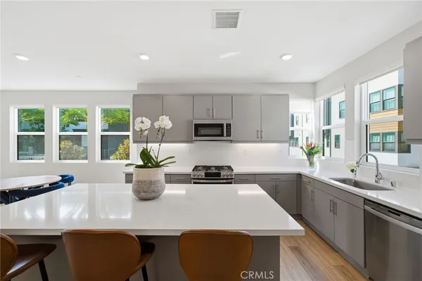 a kitchen with kitchen island granite countertop a sink a stove and refrigerator