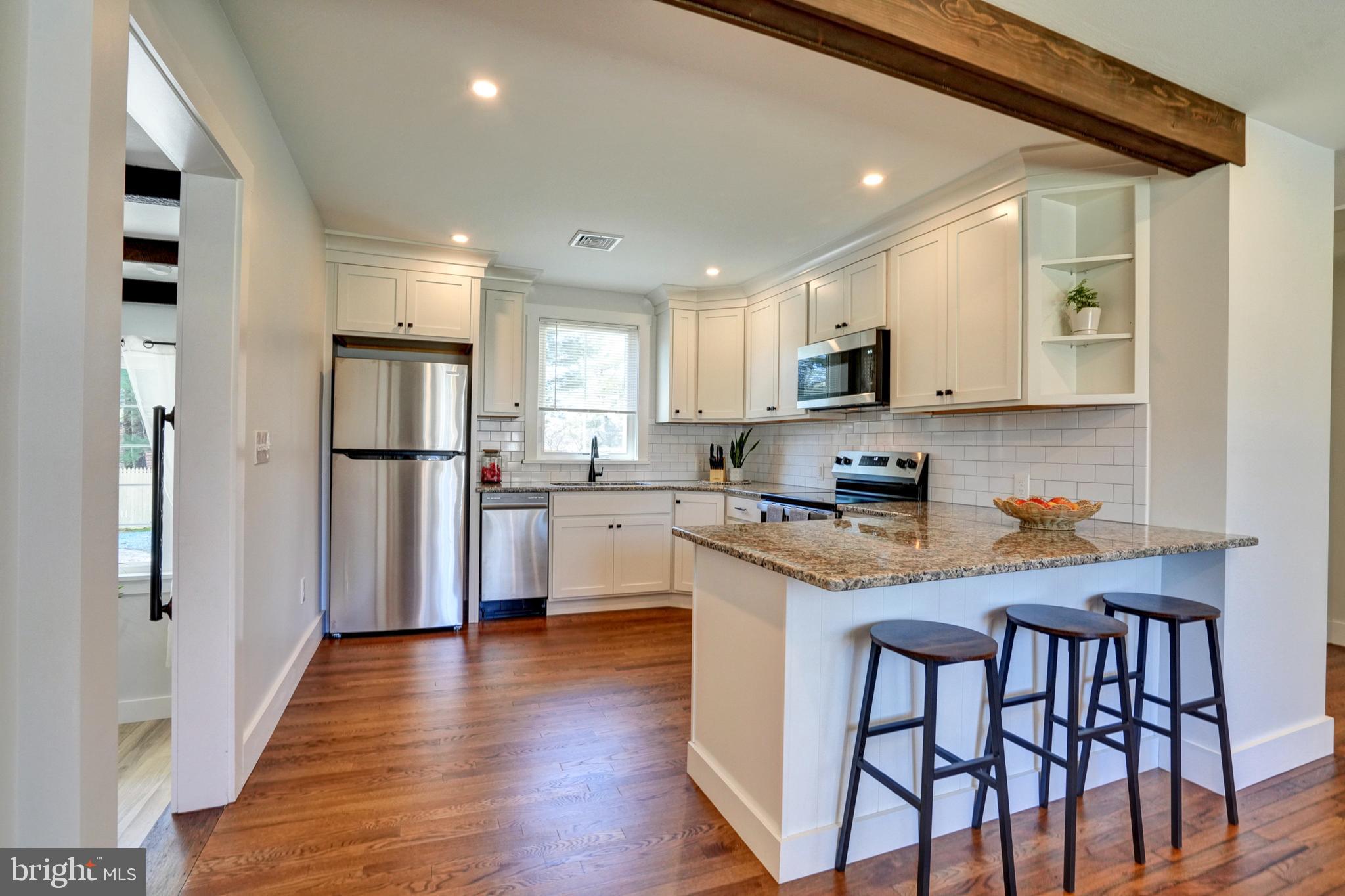 1312 Ship Road West Chester, PA 19380 - Photo 11 of 50 a kitchen with stainless steel appliances granite countertop a refrigerator a sink dishwasher a stove and white countertops with wooden floor