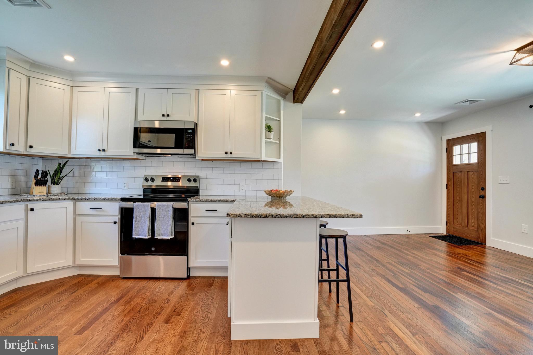 1312 Ship Road West Chester, PA 19380 - Photo 17 of 50 a kitchen with kitchen island granite countertop wooden floors and stainless steel appliances