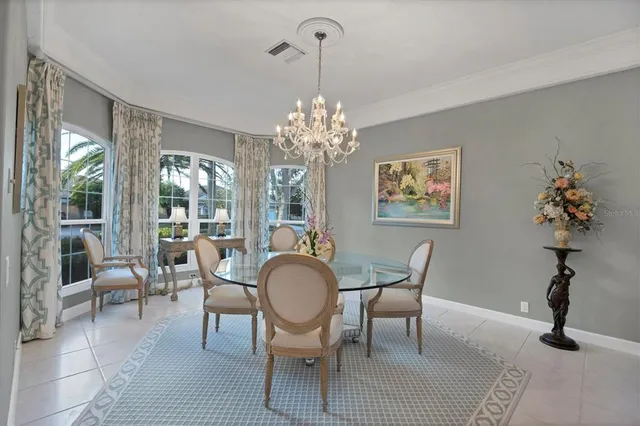 a dining room with furniture a chandelier and wooden floor