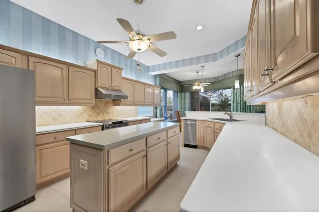 a dining room with furniture a chandelier and a large window