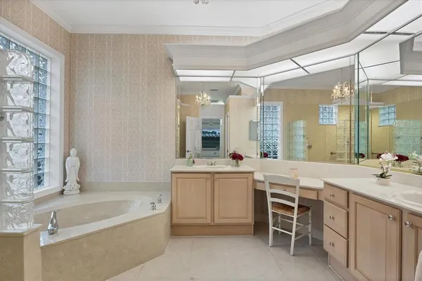 a bathroom with a granite countertop bathtub next to a window