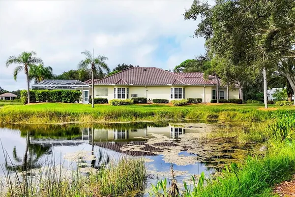 an aerial view of a house with a garden and lake view