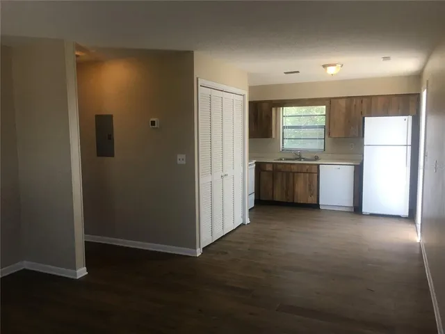 a view of an empty room with a kitchen