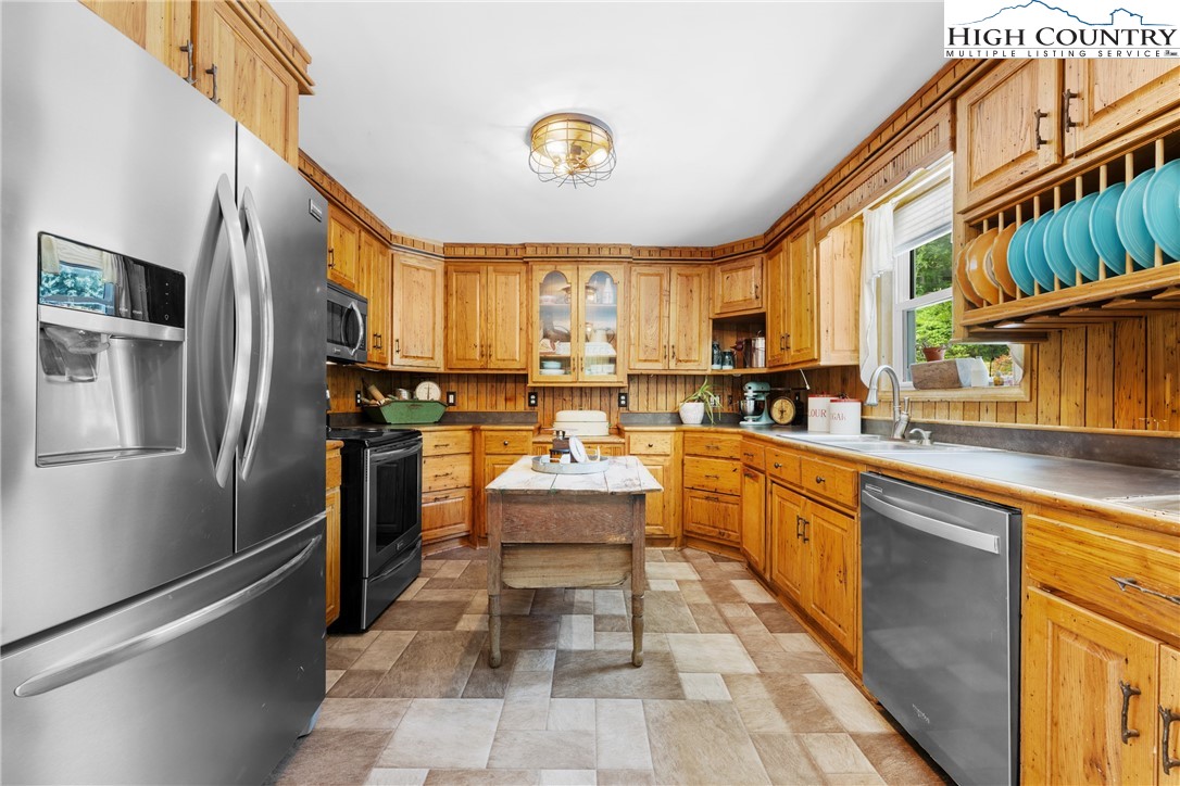 261 Tumbling Brook Road Banner Elk, NC 28604 - Photo 17 of 39 a kitchen with stainless steel appliances granite countertop a stove a sink dishwasher and a refrigerator