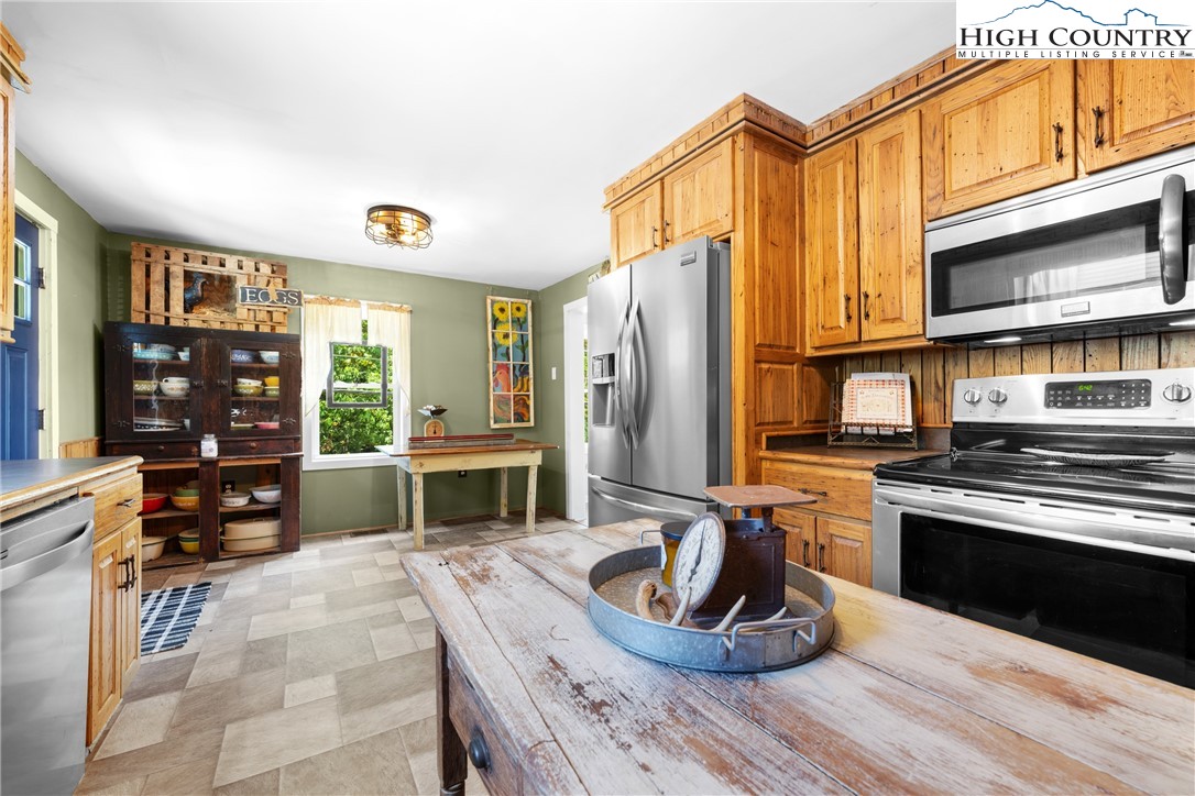 261 Tumbling Brook Road Banner Elk, NC 28604 - Photo 19 of 39 a kitchen with stainless steel appliances granite countertop a stove and a refrigerator