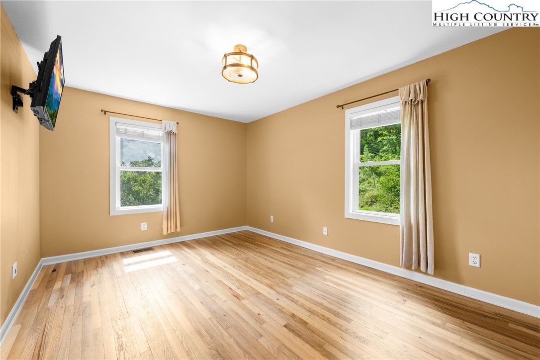 261 Tumbling Brook Road Banner Elk, NC 28604 - Photo 21 of 39 a view of an empty room with window and wooden floor