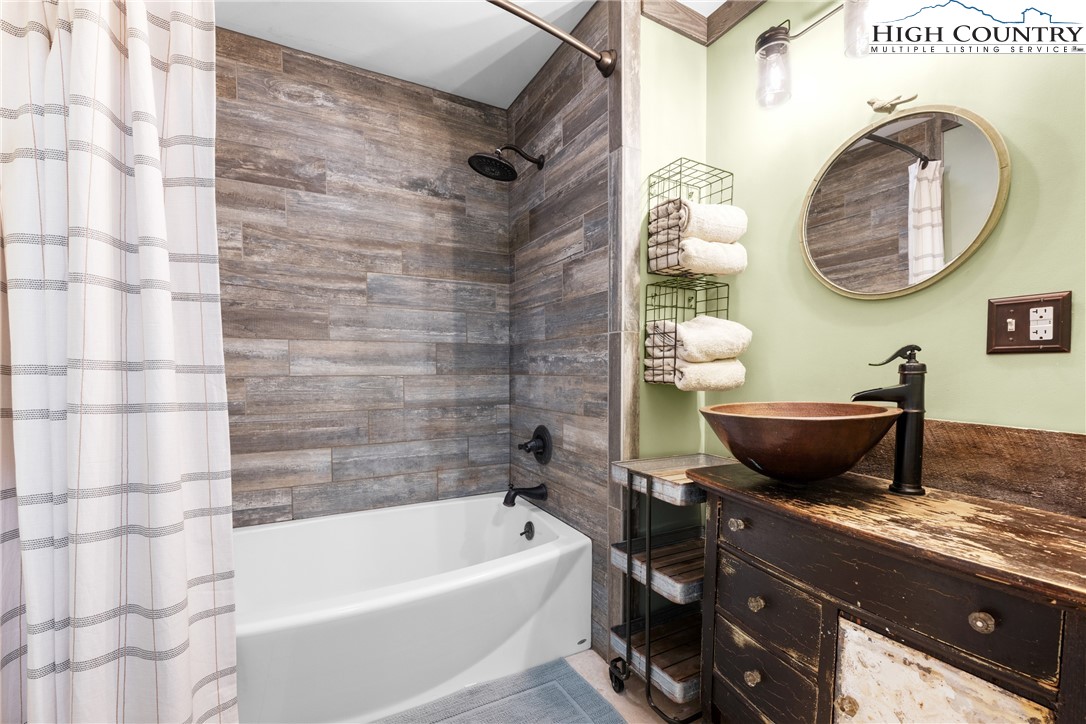 261 Tumbling Brook Road Banner Elk, NC 28604 - Photo 23 of 39 a bathroom with a granite countertop sink and a mirror