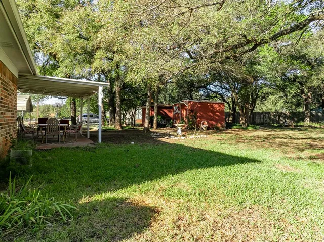 a view of backyard with a table and chairs and potted plants
